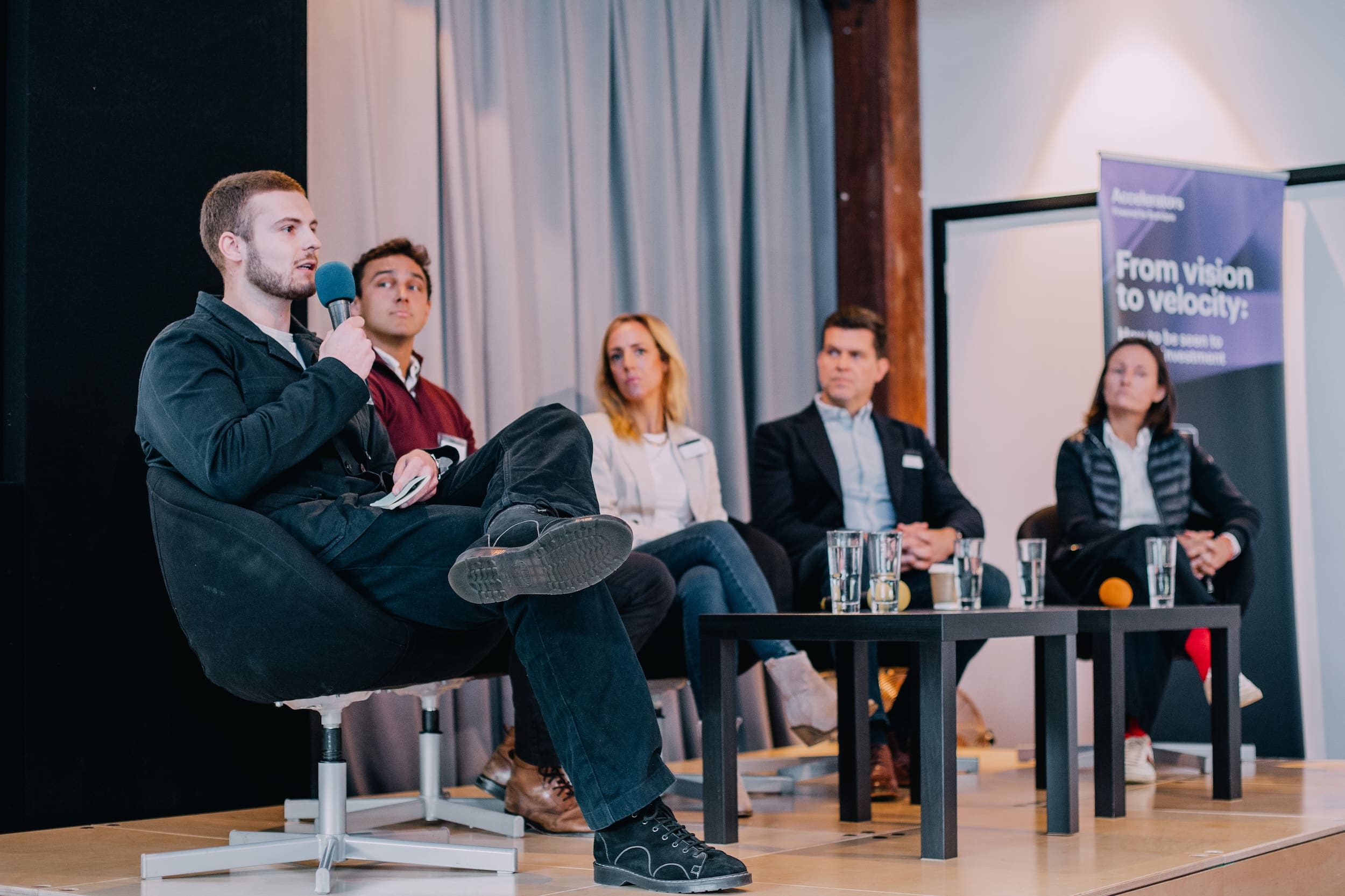 A panel of business leaders speaking at an event about visibility and investment, discussing how clarity and brand alignment unlock business growth.